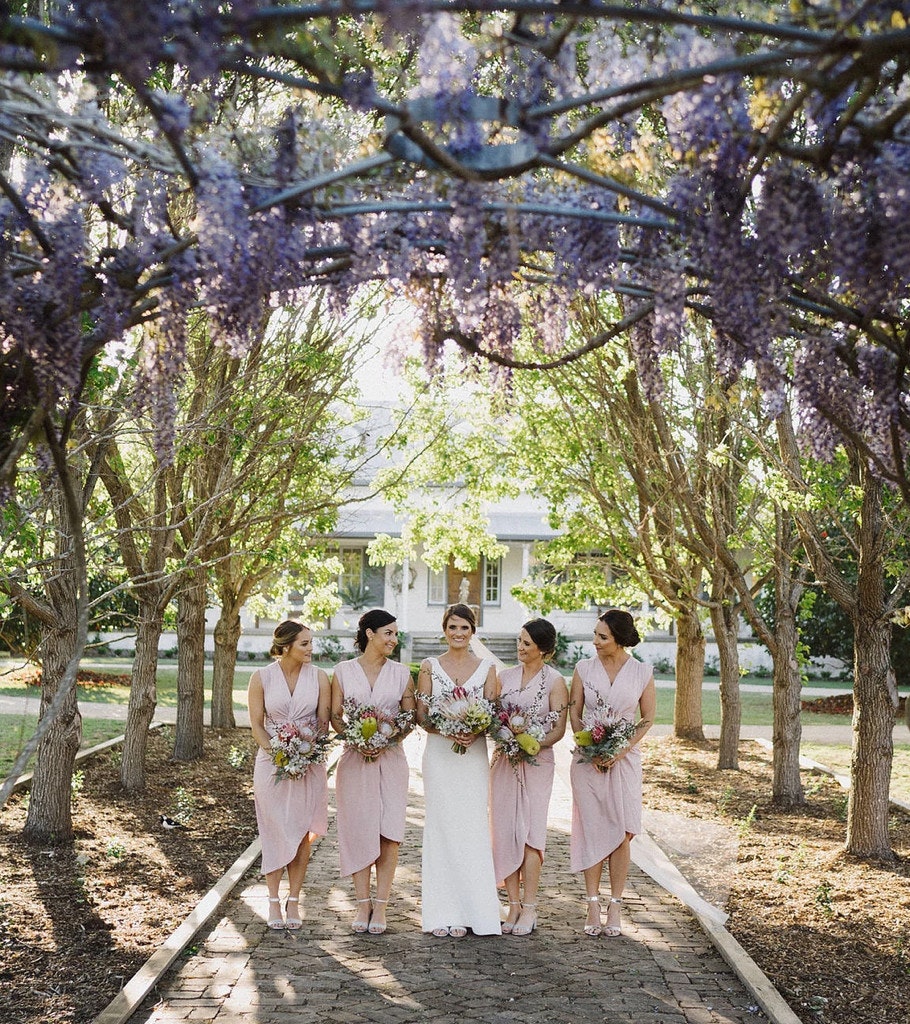 Bridal party underneath flowering trees.